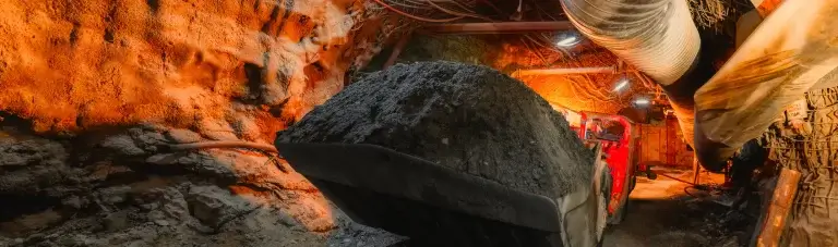 Mining shovel carries coal in an underground tunnel